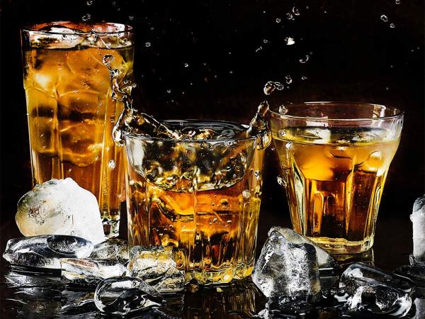 three glasses of bourbon with ice