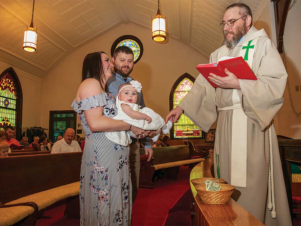 pastor robert ford baptizing a baby parishioner