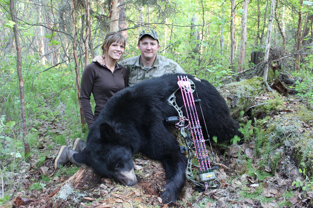 man and woman bowhunting a black bear