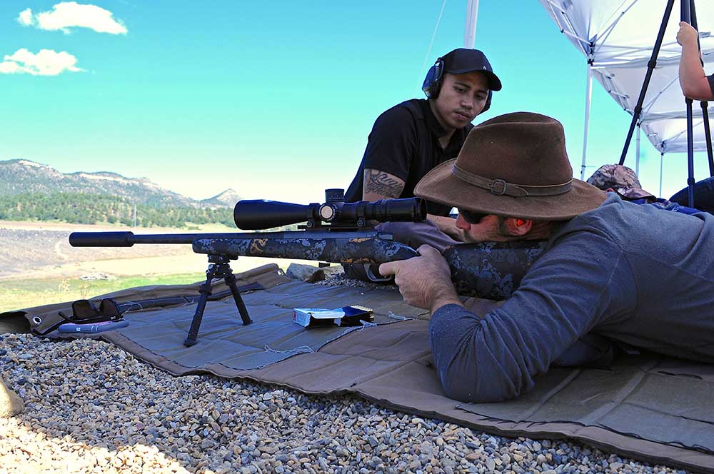 man aiming long range rifle at shooting class
