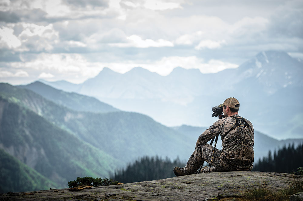 hunter in british columbia using a spotting scope for bear hunting