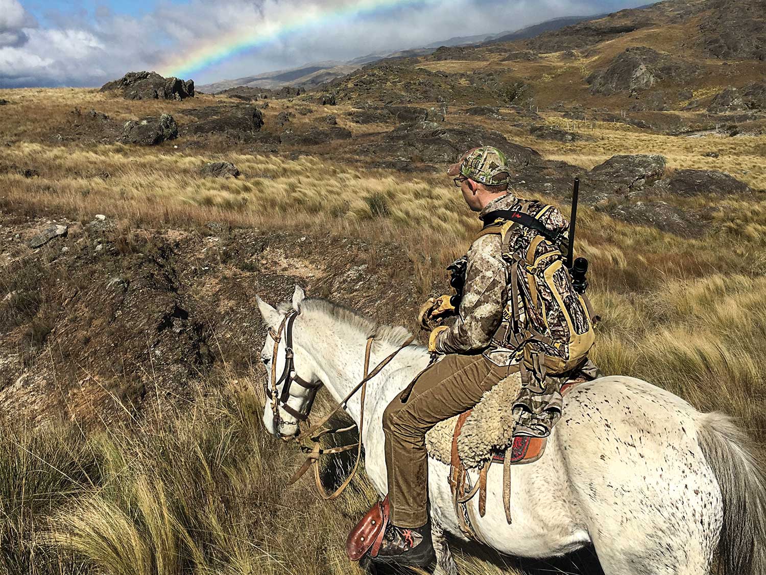 hunter riding horseback through Argentina hillsides