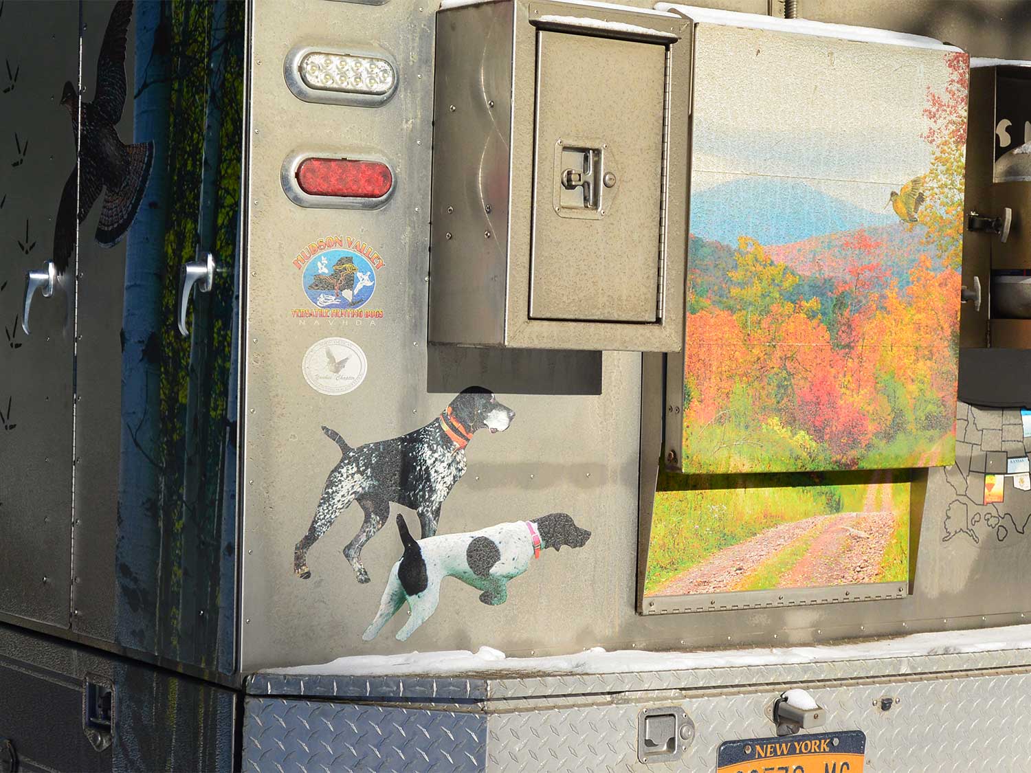 paintings of hunting dogs and landscape on the side of a truck