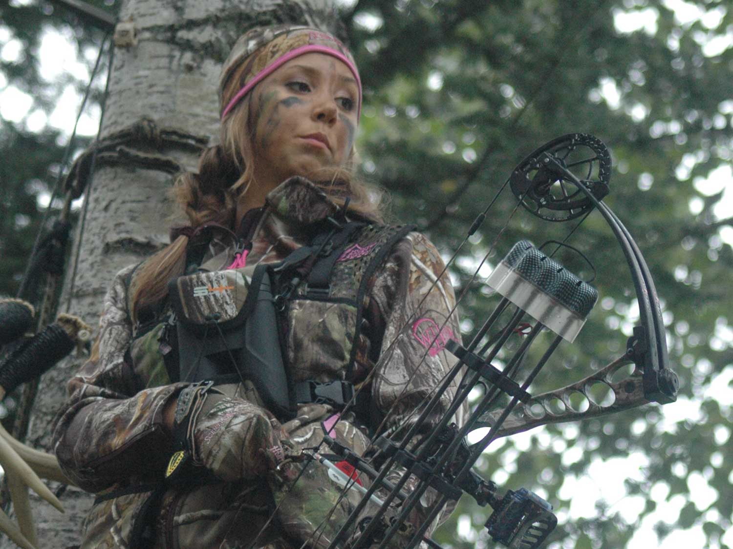 female hunter holding a compound bow