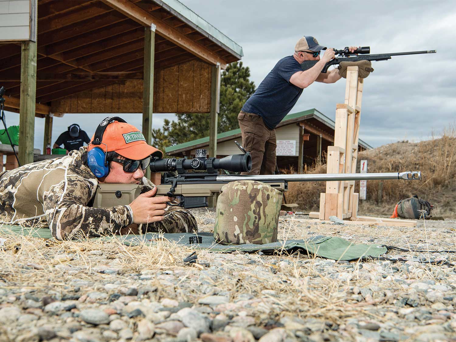 two men aiming rifles gun range