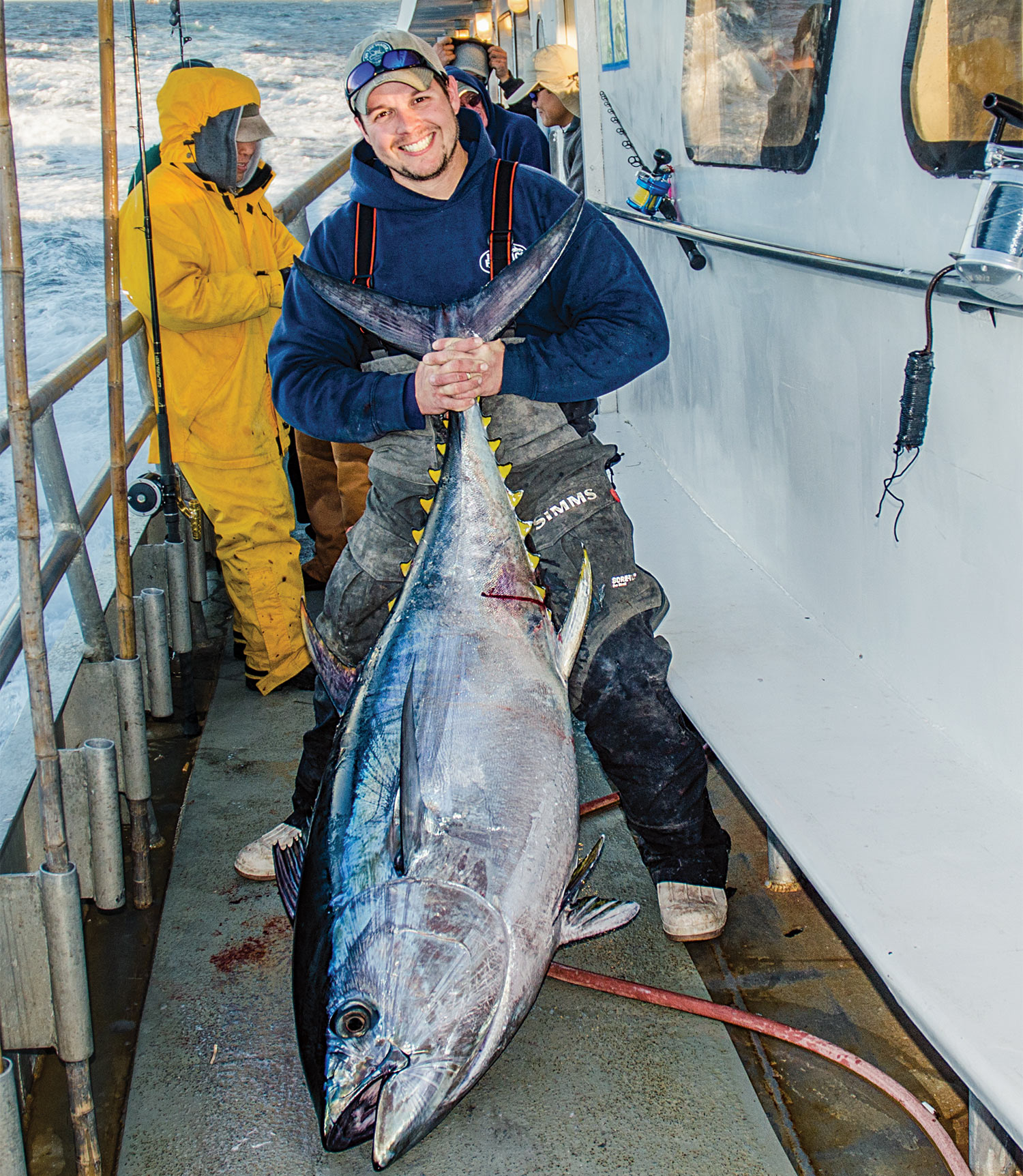 Jimmy Fee holding a giant bigeye tuna on the deck of a boat