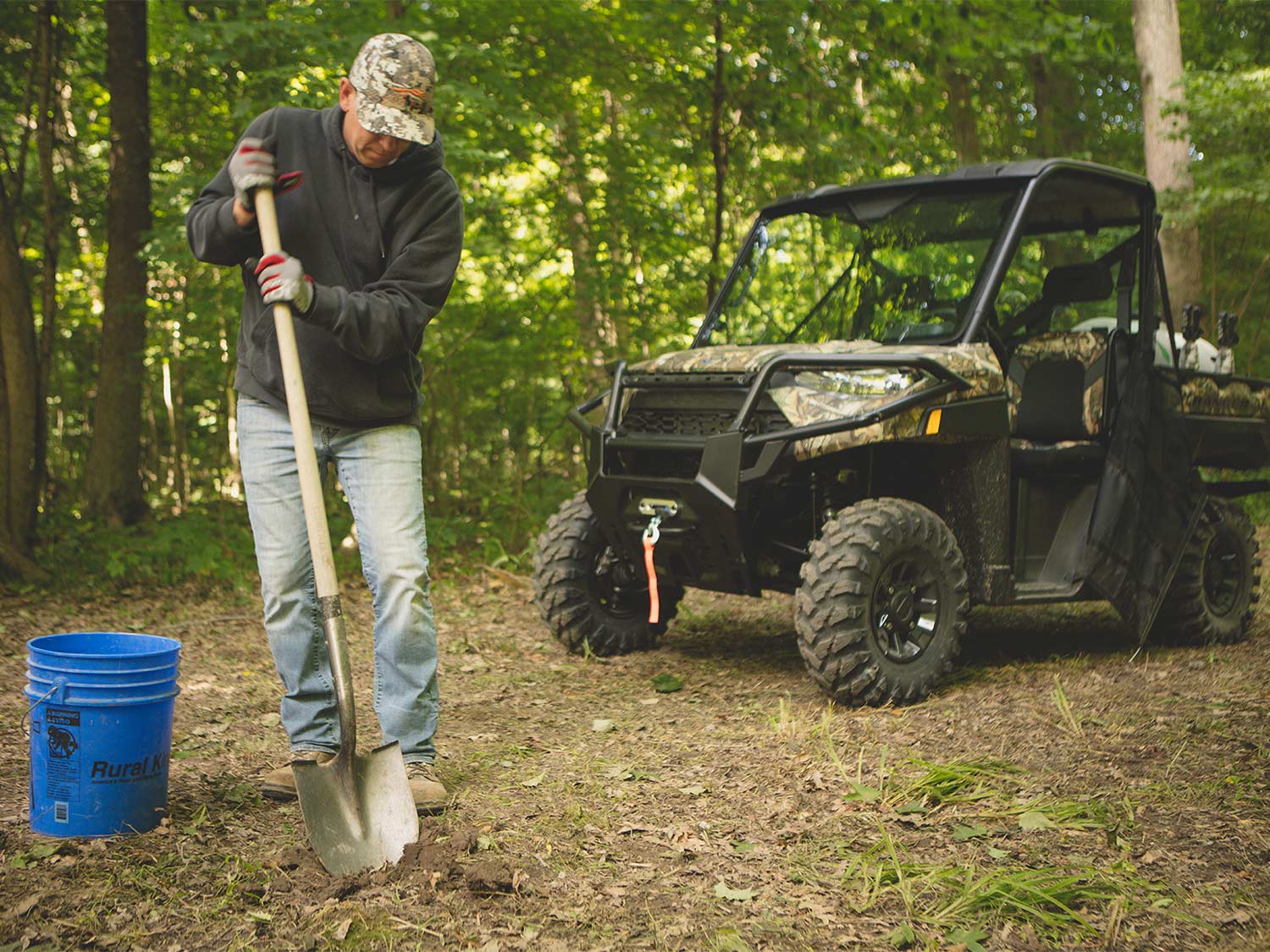 man digging with shovel in a food plot