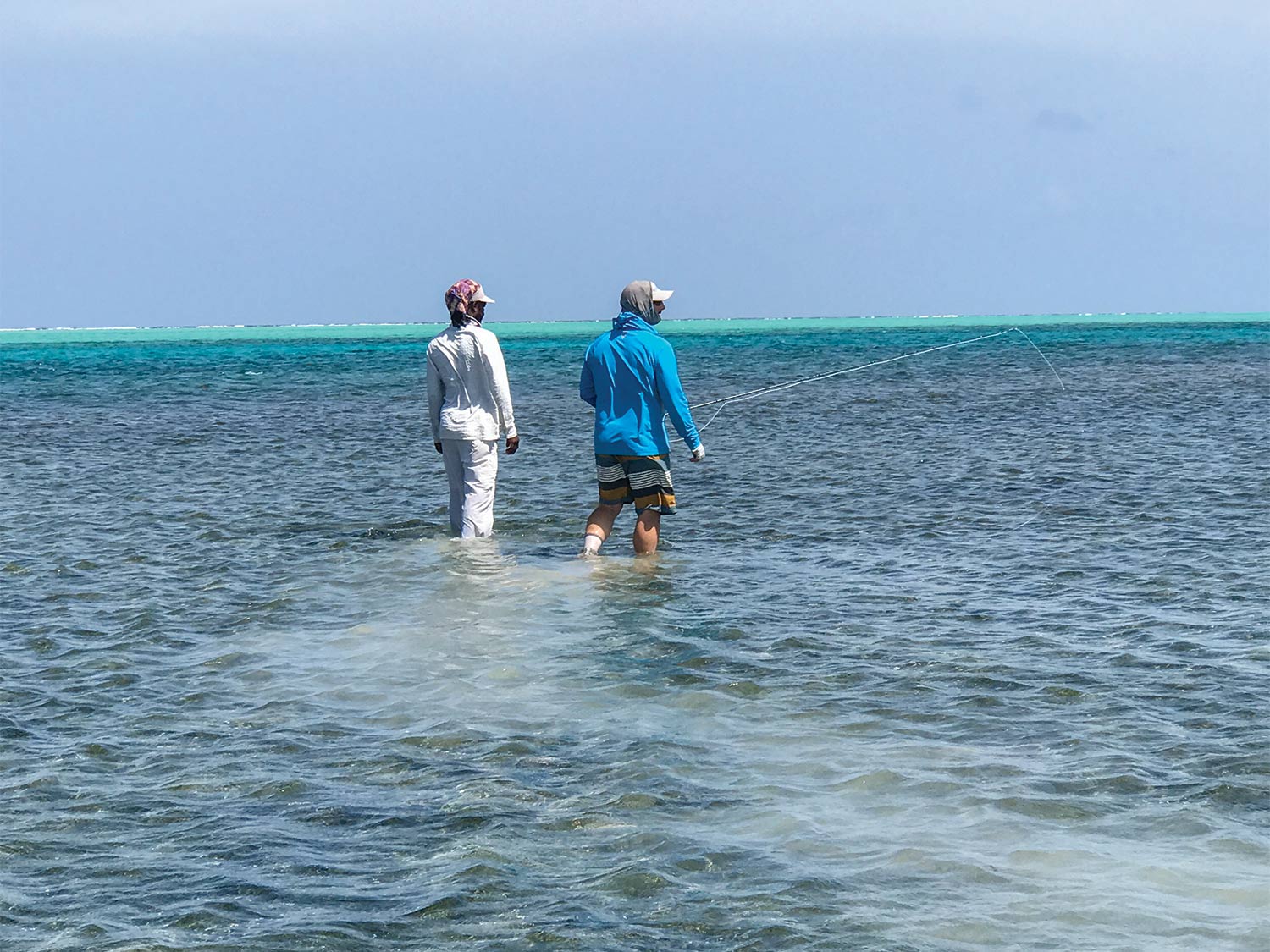 two anglers walking through the saltwater Turneffe Flats