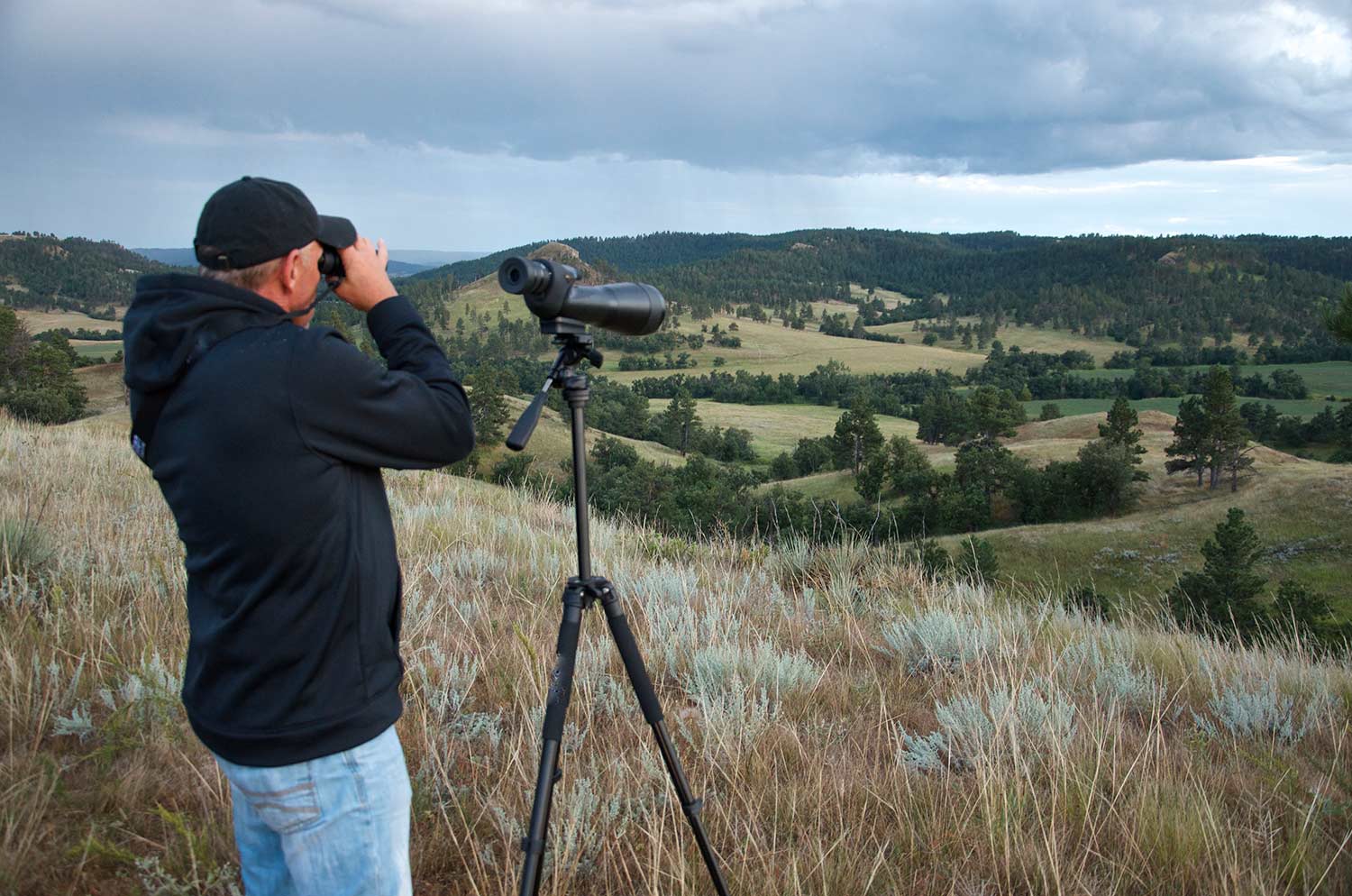 a hunter using binoculars and spotting scopes