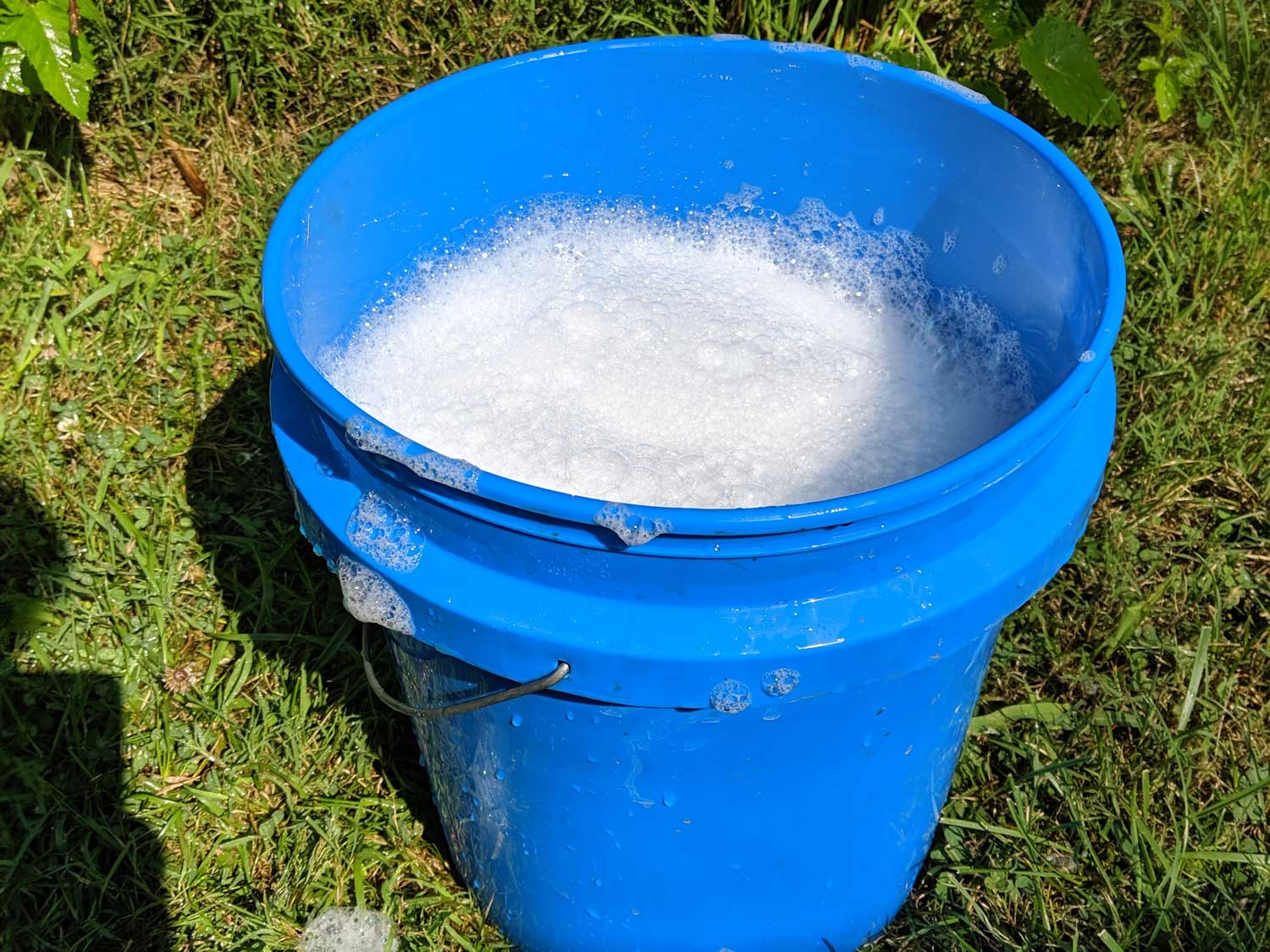 a blue bucket full of soapy water