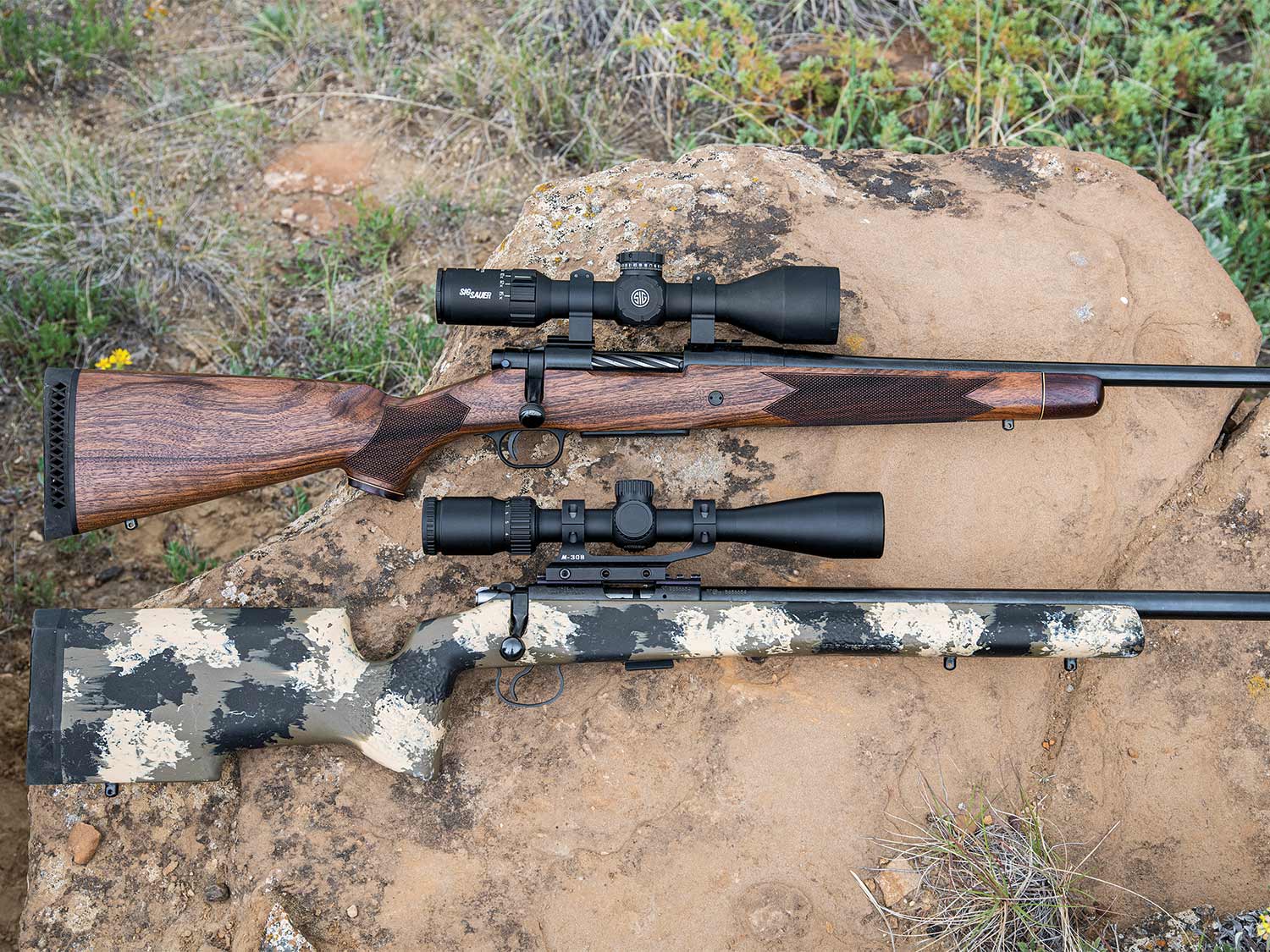 two rifles with rifle scopes