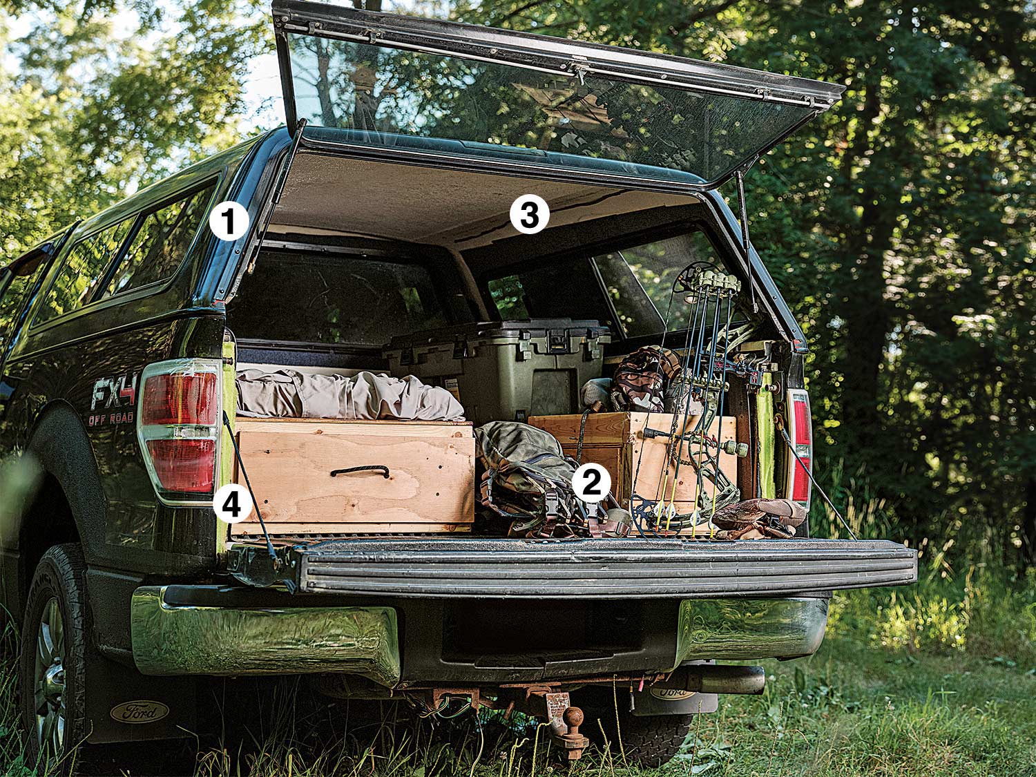 a truck bed storage full of hunting gear