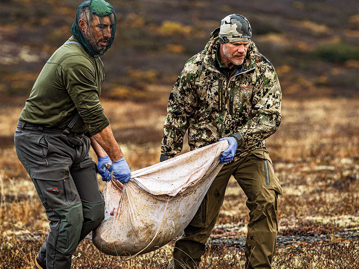two hunters hauling packed out elk meat