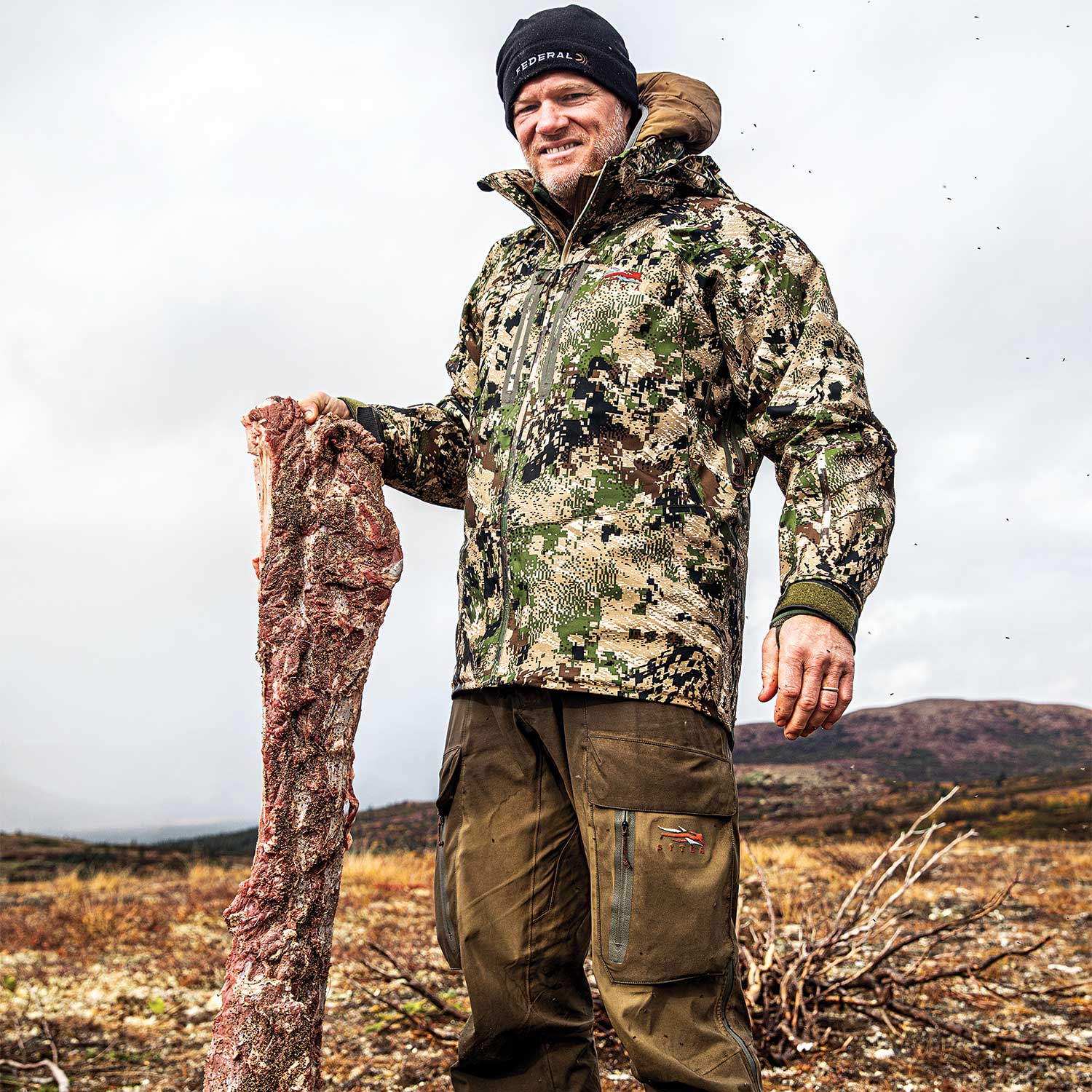 hunter holding up an peppered elk backstrap