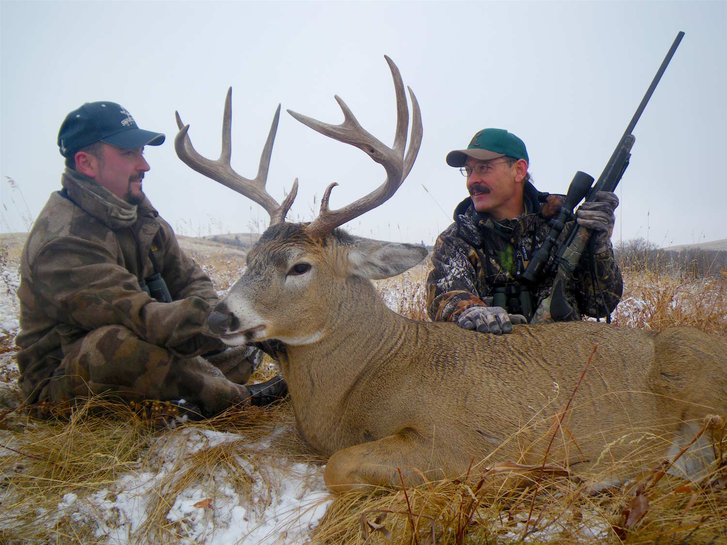 two hunters and a whitetail buck