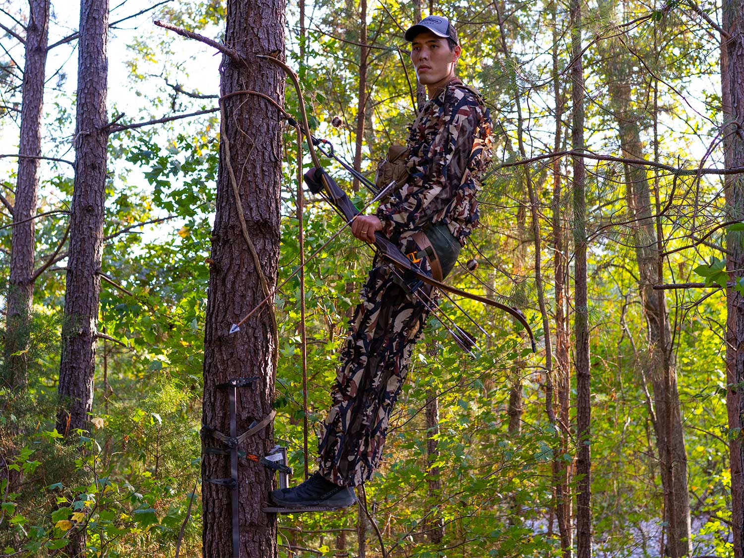 hunter standing in a tree saddle platform