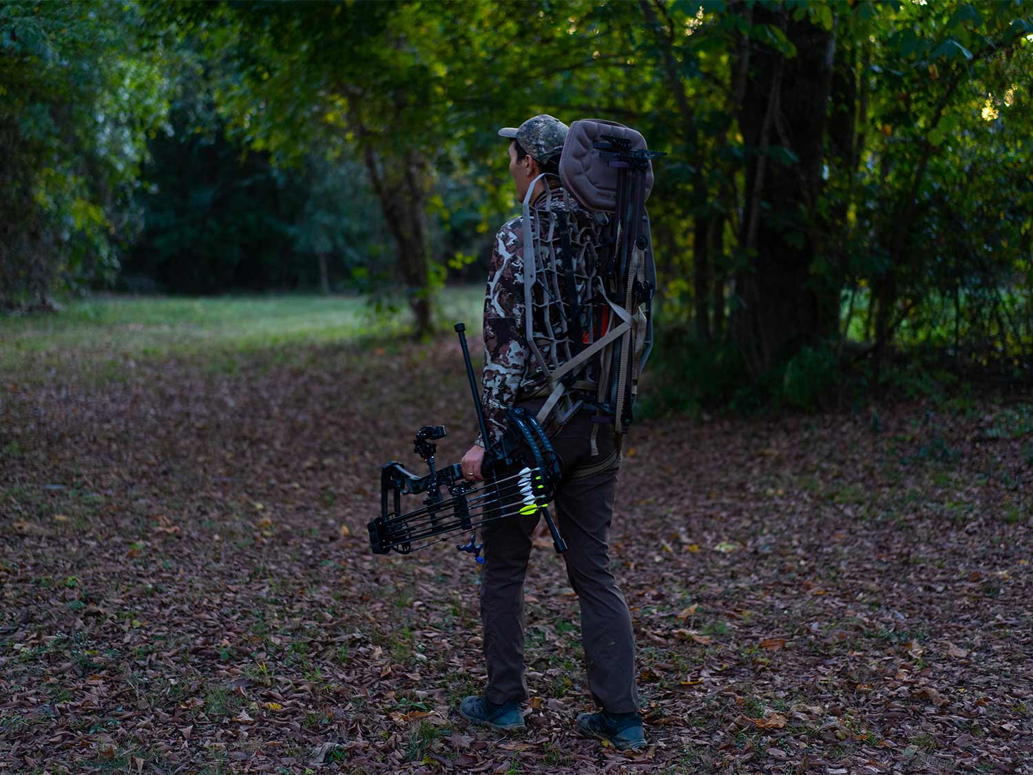 hunter carrying a mobile treestand through the woods.
