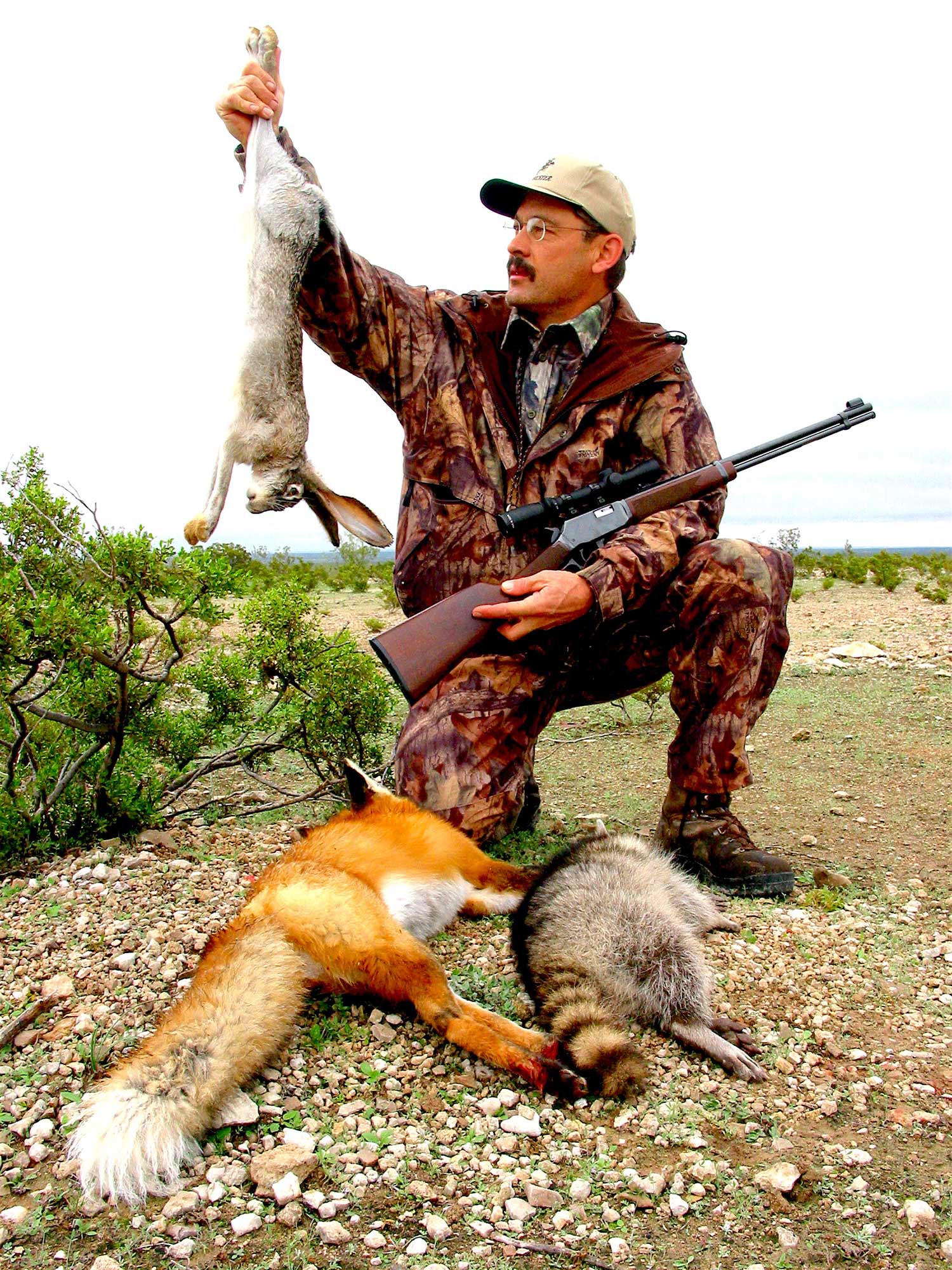 a hunter holding up a small game rabbit