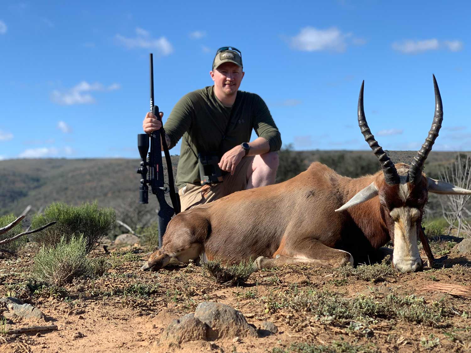 Tyler Freel kneeling behind a Blesbok hunted in Africa.
