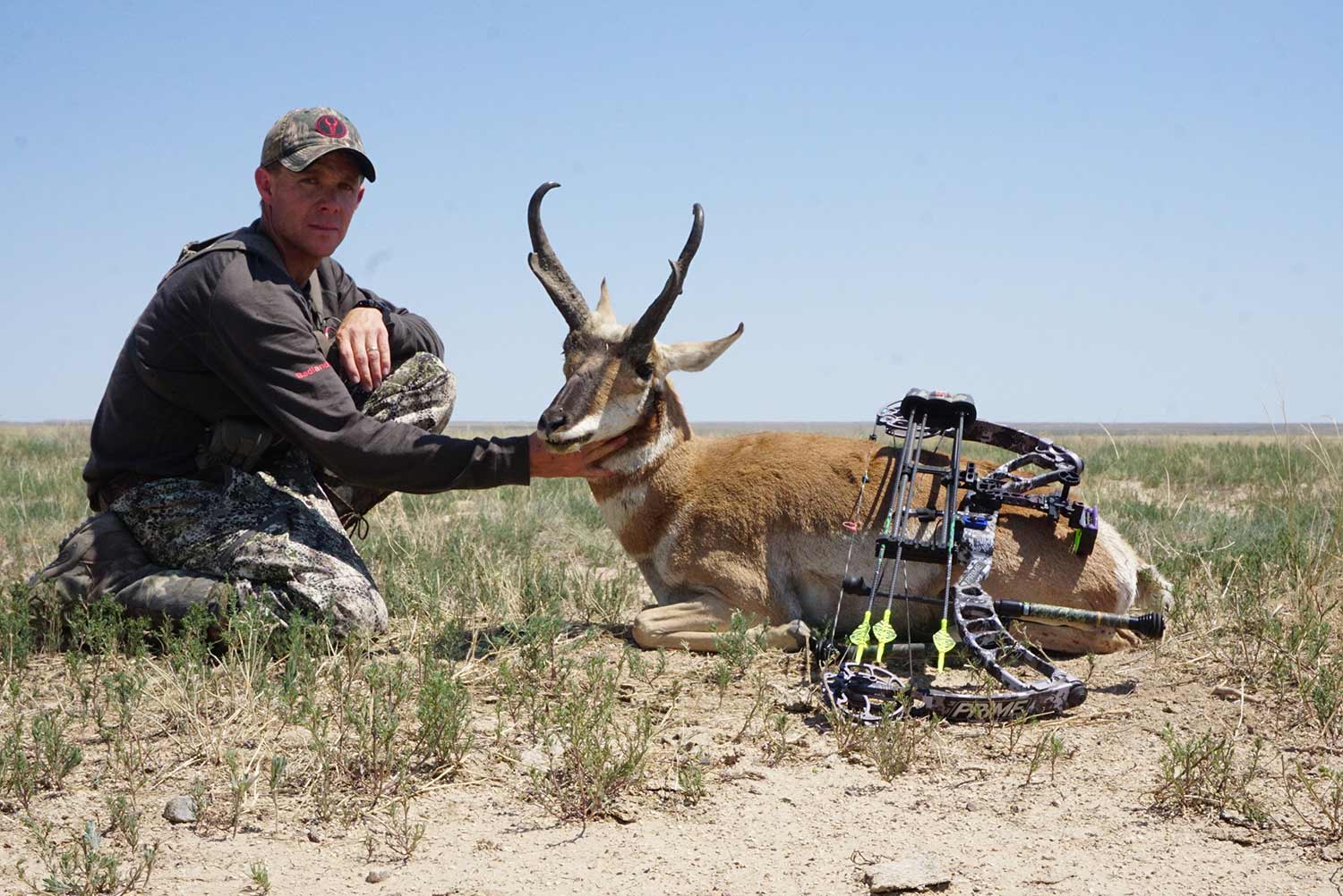 A hunter kneeling beside a South Dakota antelope.