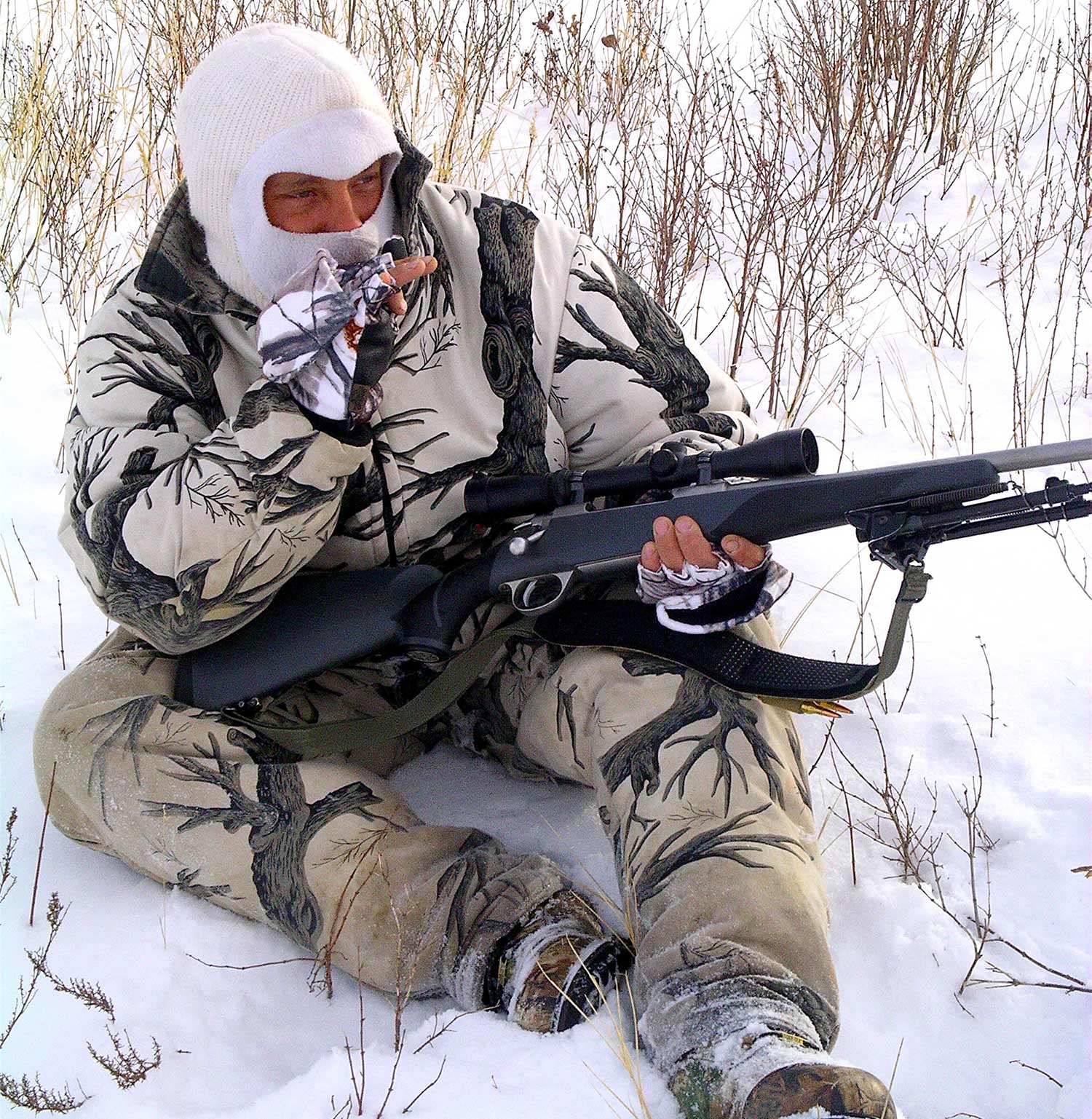 A hunter sitting in the snow.