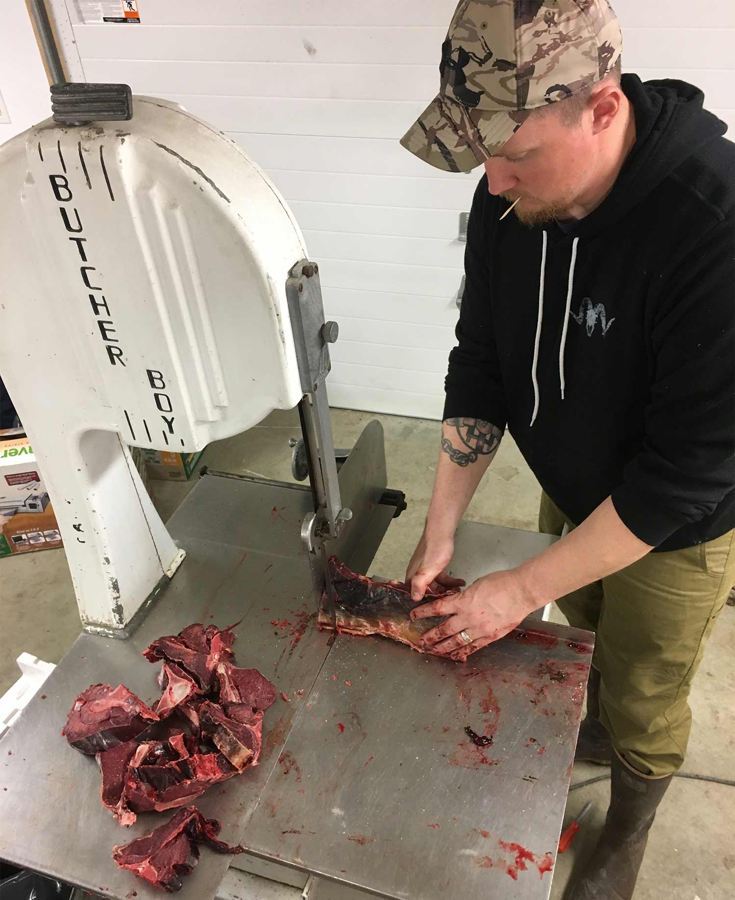 Tyler Freel processing caribou meat after a hunt.