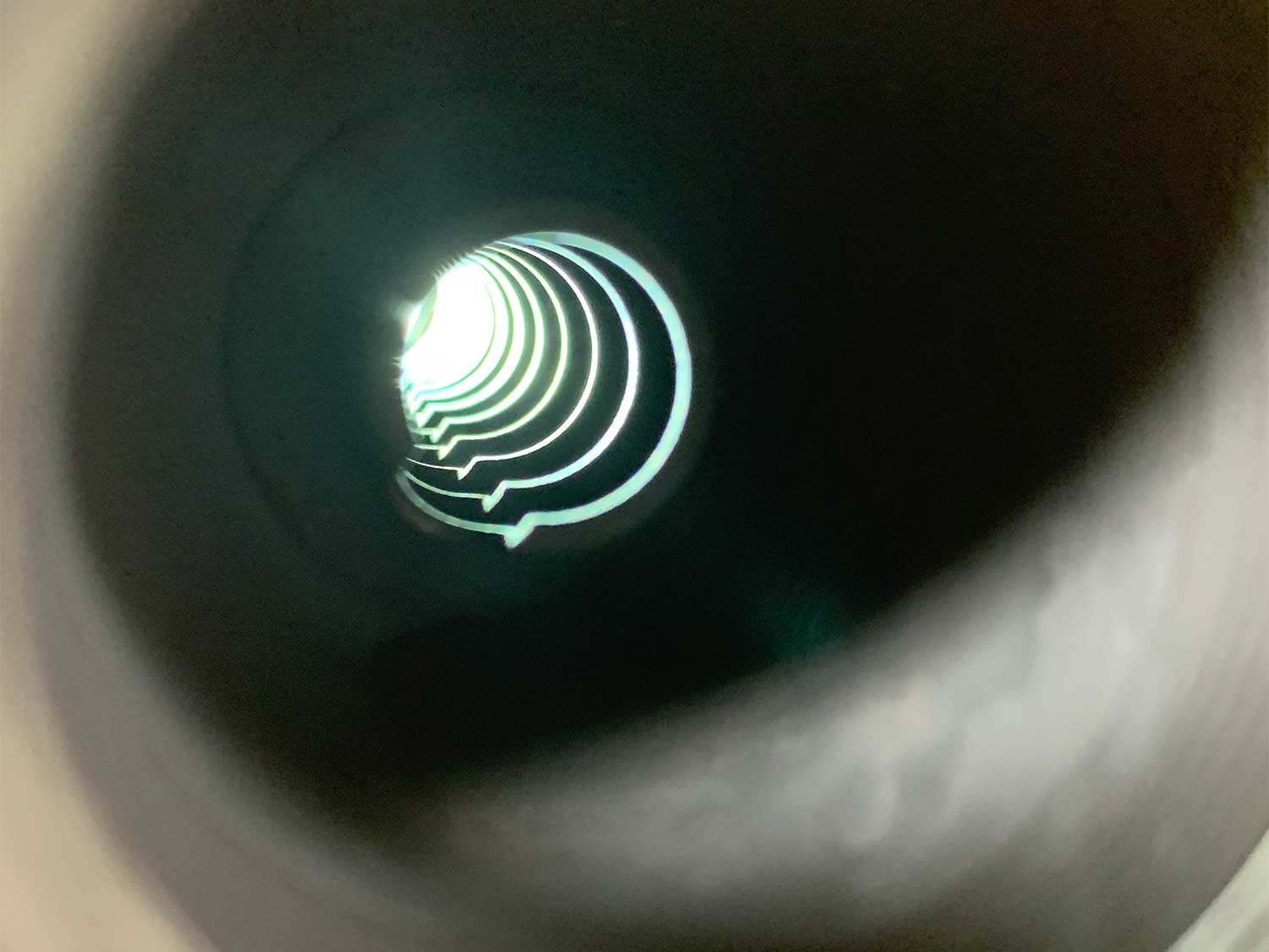 A look down the inside a suppressor, showing baffles and chambers.
