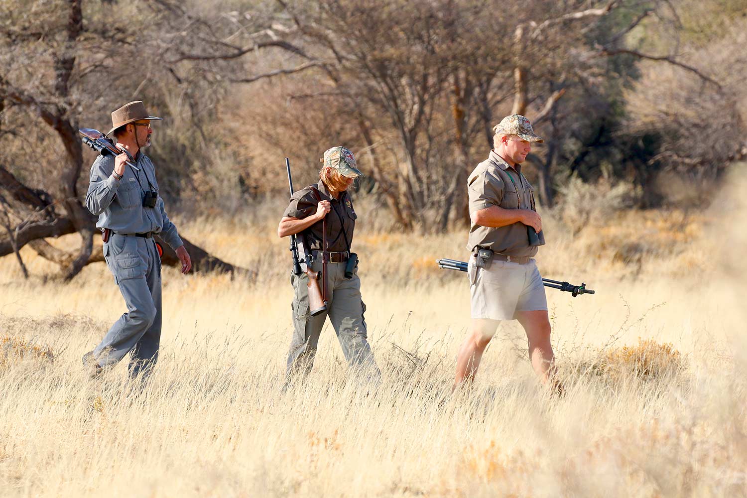 Hunters walking through the fields in Africa.