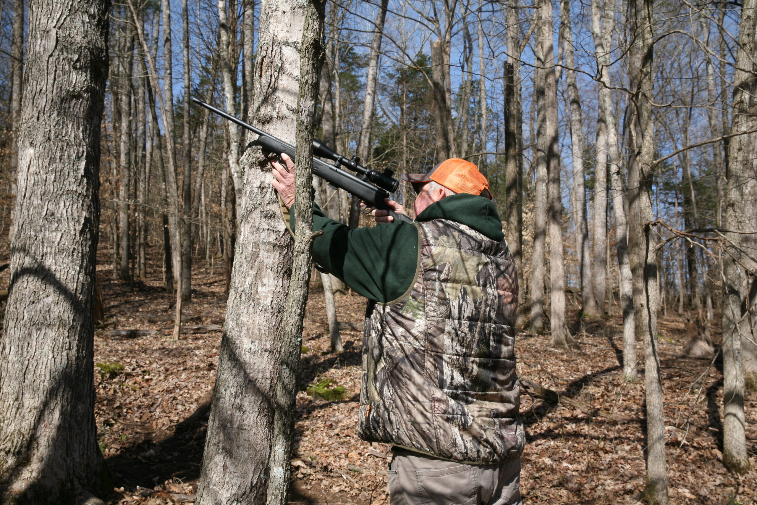 Hunter shooting at a squirrel.