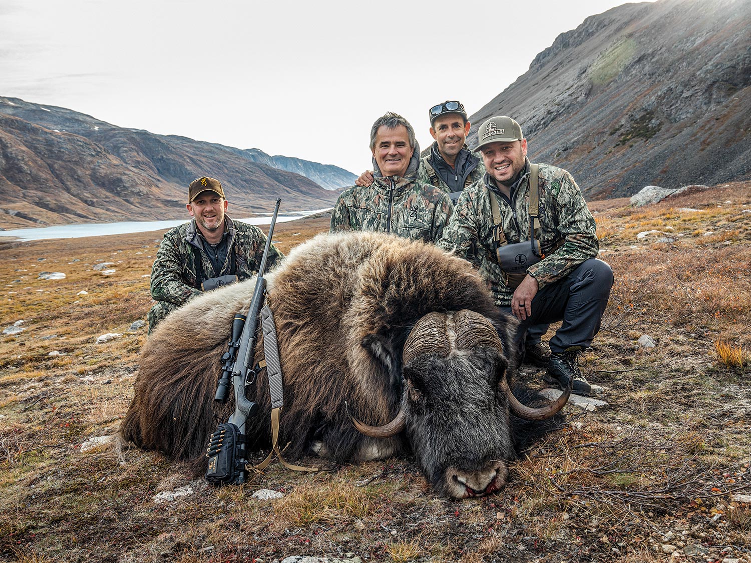 A hunting party posing with a musk ox.