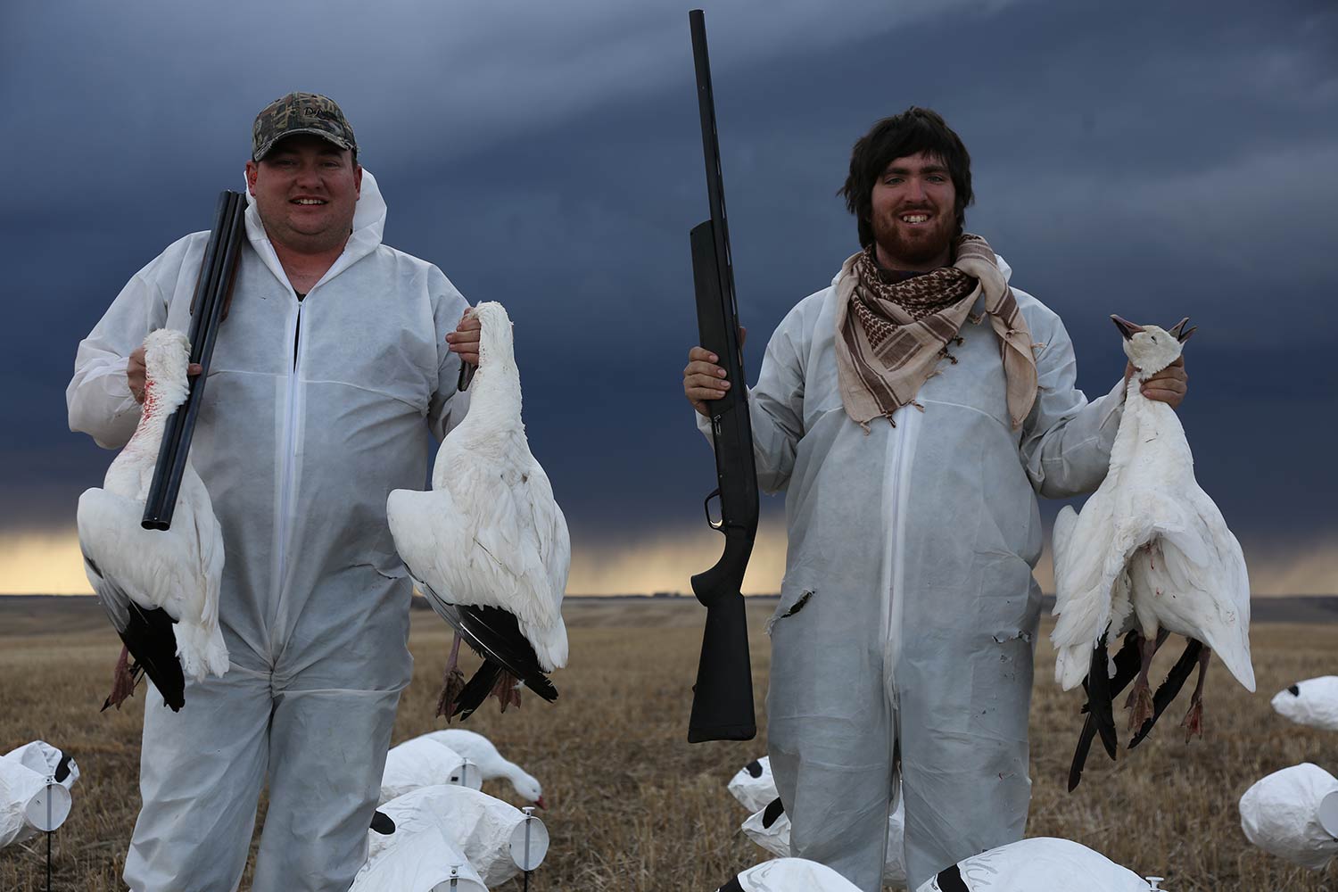 Hunters holding up snow geese.