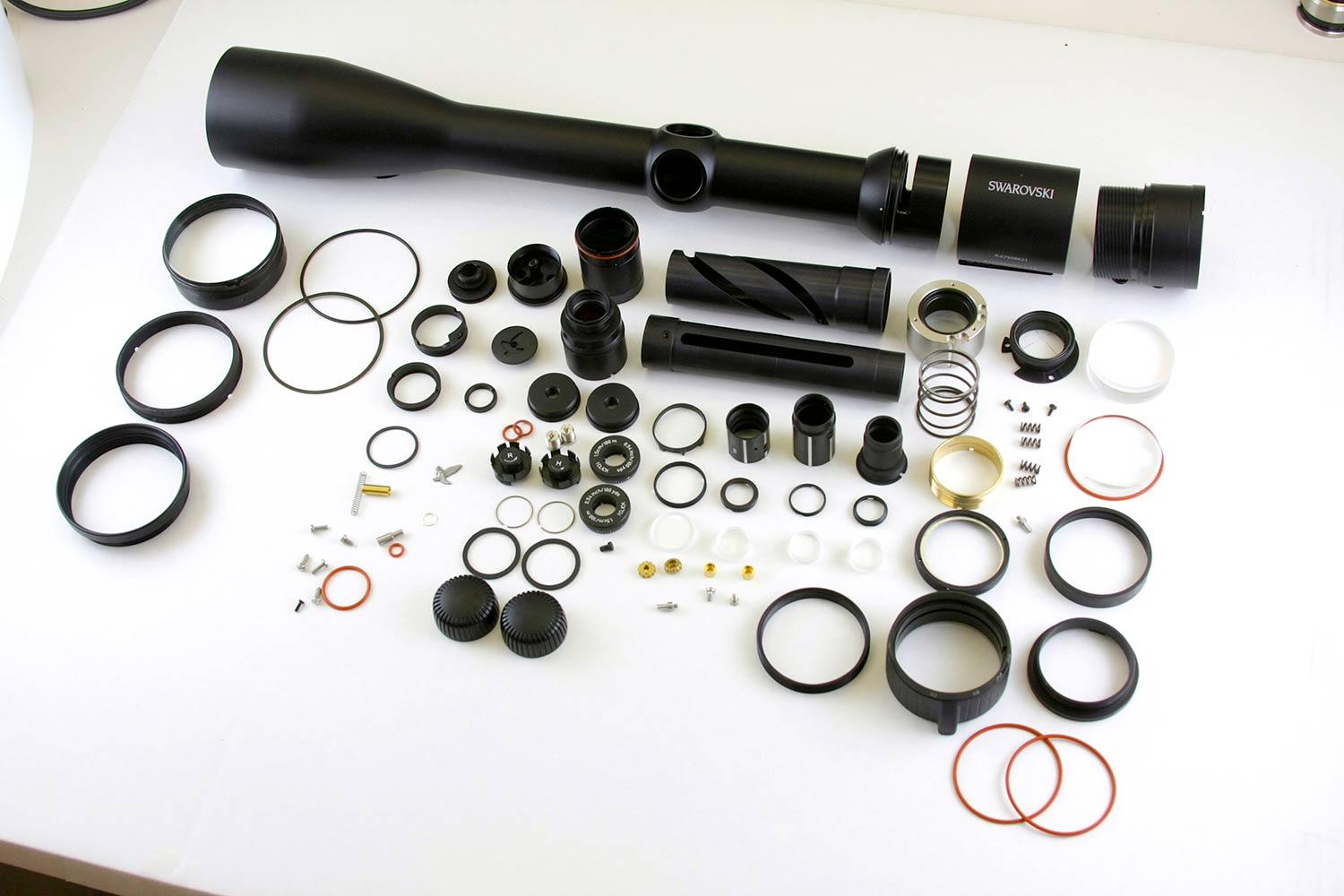 Riflescope parts on a white table.