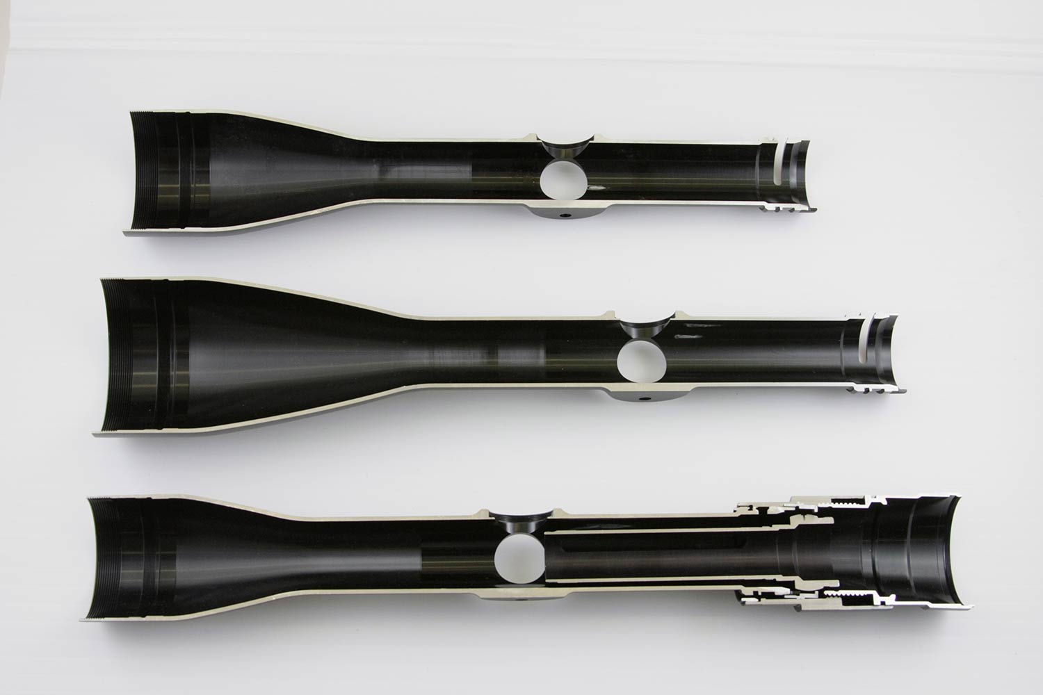 Three riflescopes on a white background.