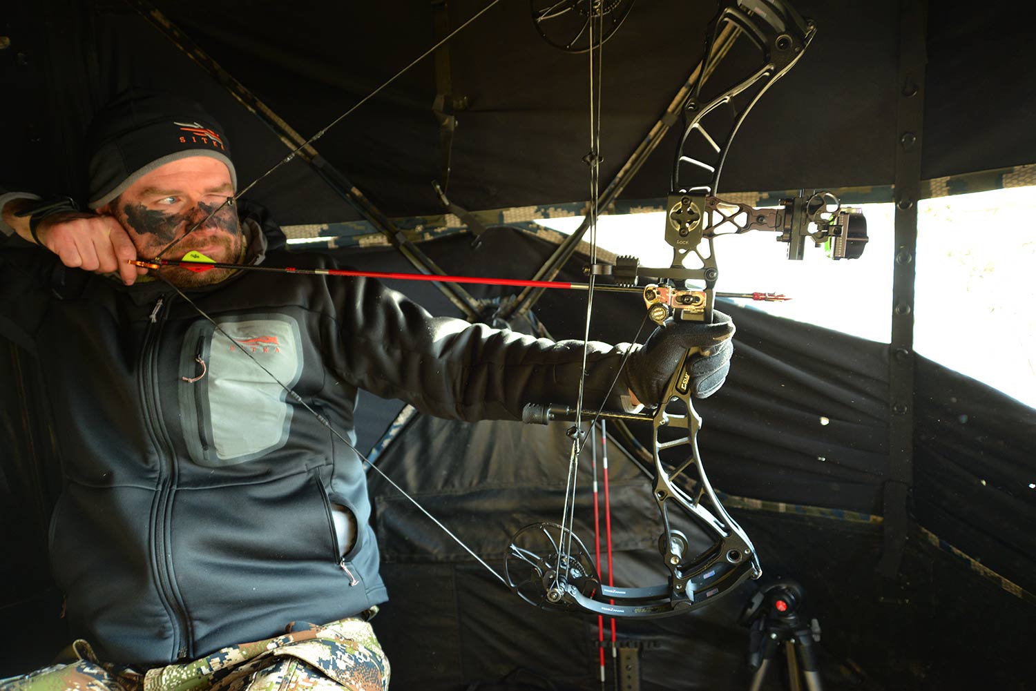 A bowhunter pulling back on a compound bow.