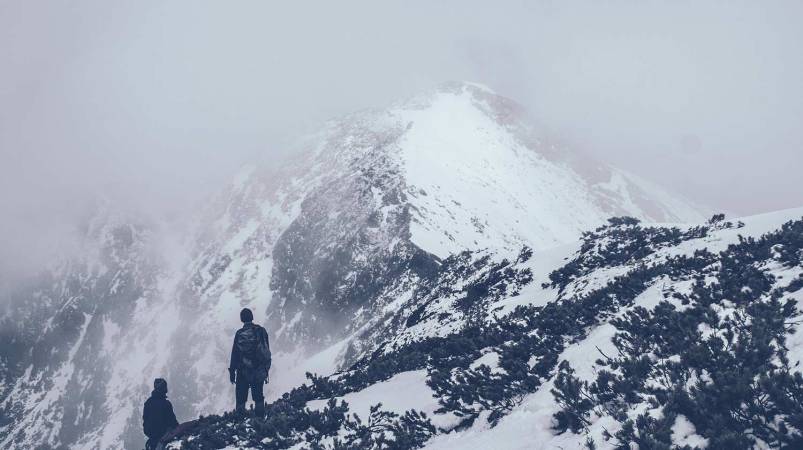 Hiker climbing a snowy mountain.