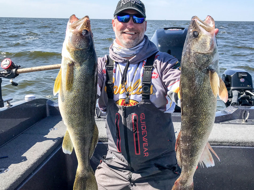 Brian Bashore holding up two large walleye.