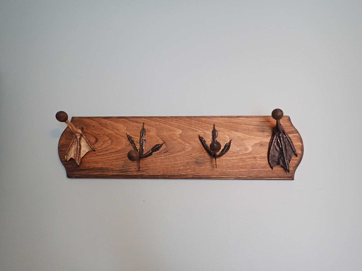 A hat rack made of wood and duck feet.