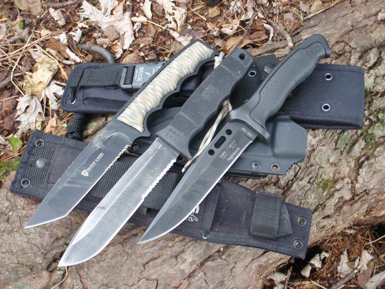 A trio of knives on a rock.