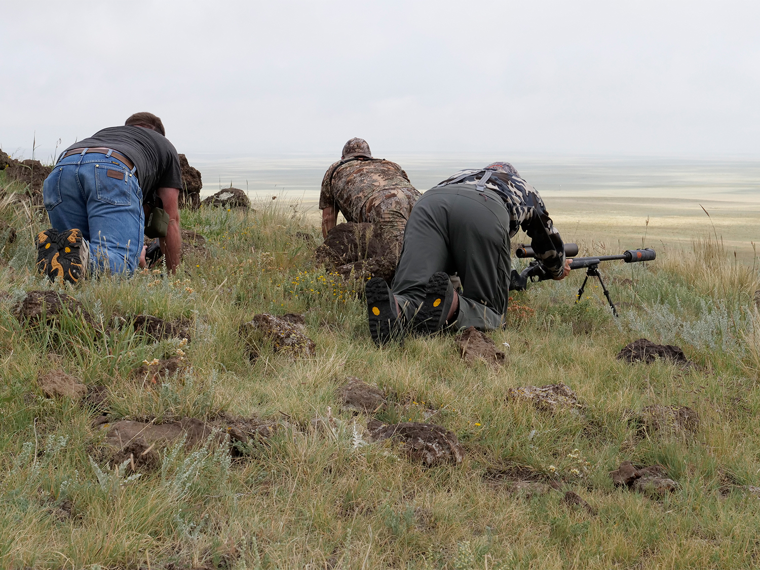 Hunters setting up rifle shooting spots on a hillside.