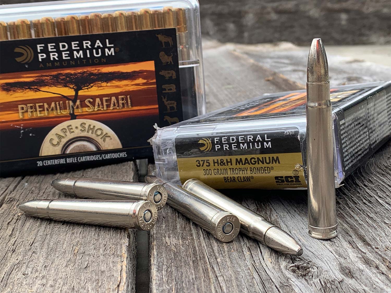 Several magnum hunting cartridges on a wooden table.