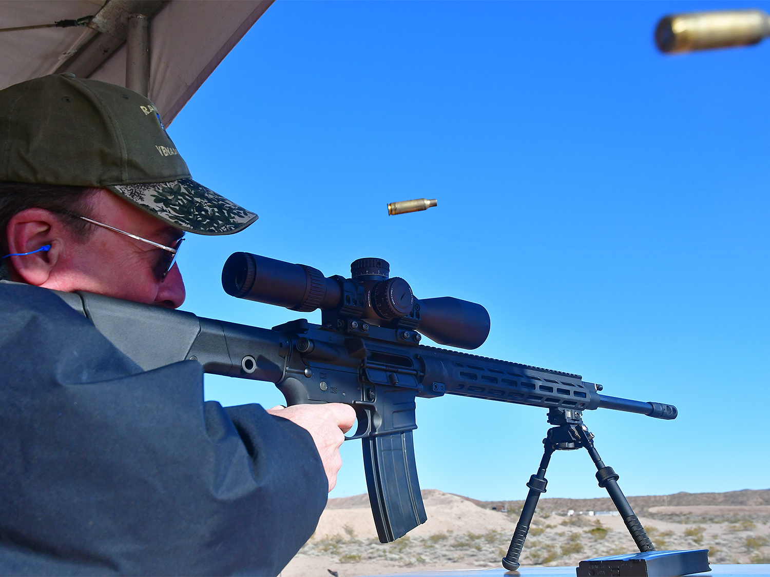 A hunter aiming a rifle at a shooting range.