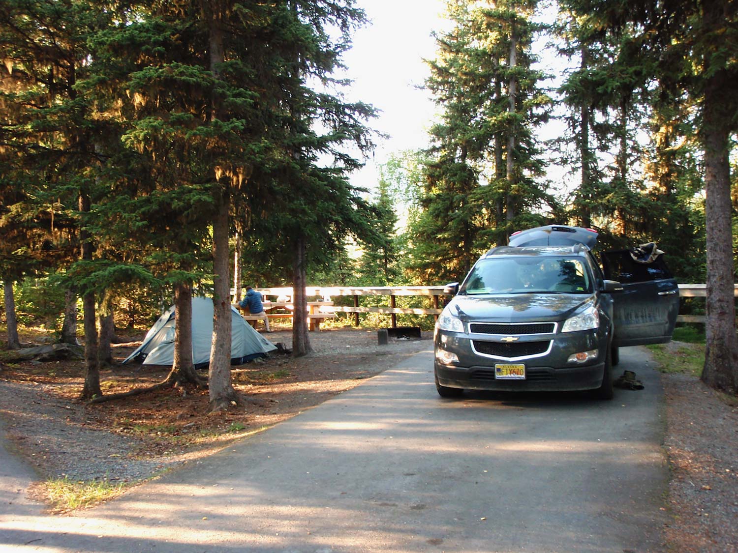 A small hunting campground with a Chevrolet vehicle parked nearby.