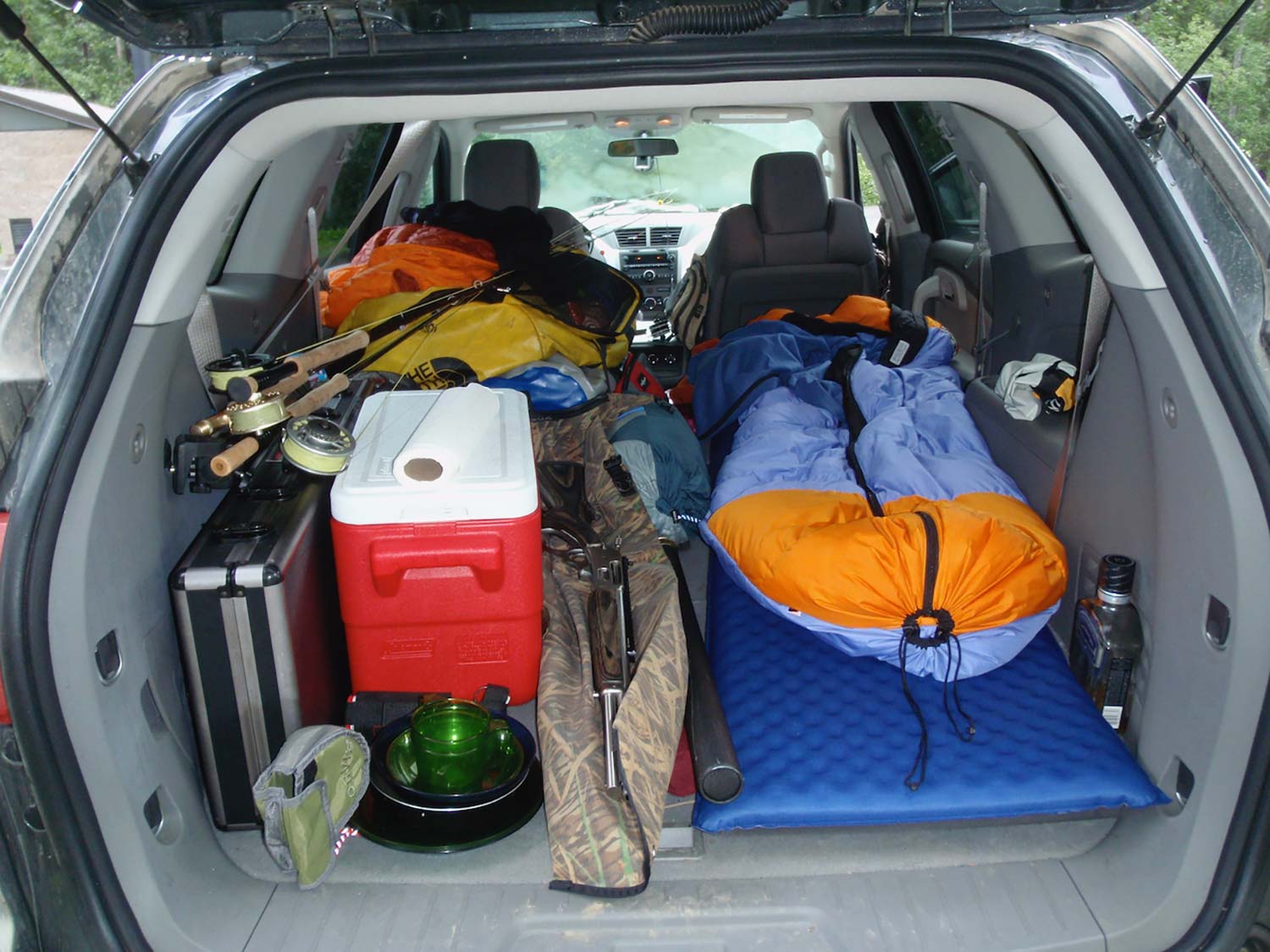 Piles of hunting and camping gear packed into the back of a hunting vehicle.