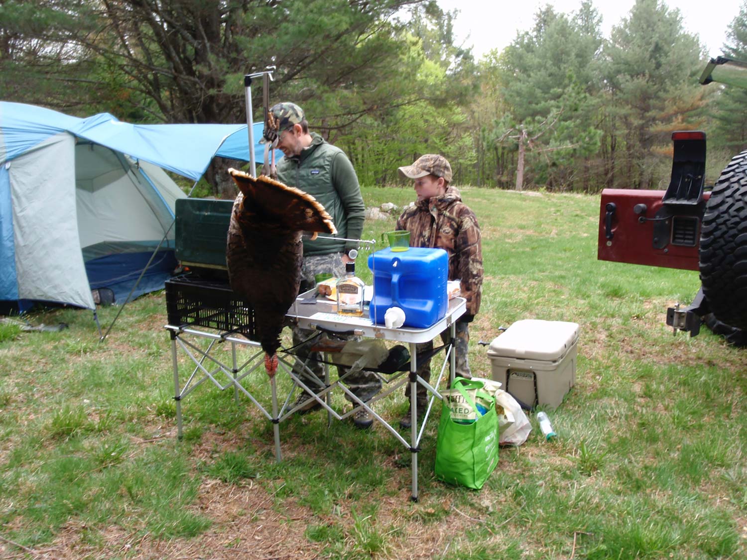 Two hunters cooking at a campground.