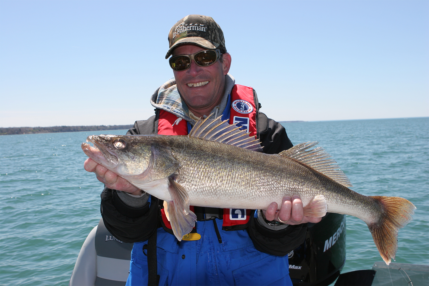 Angler holds up a large trophy walleye at the Great Lakes in Michigan.