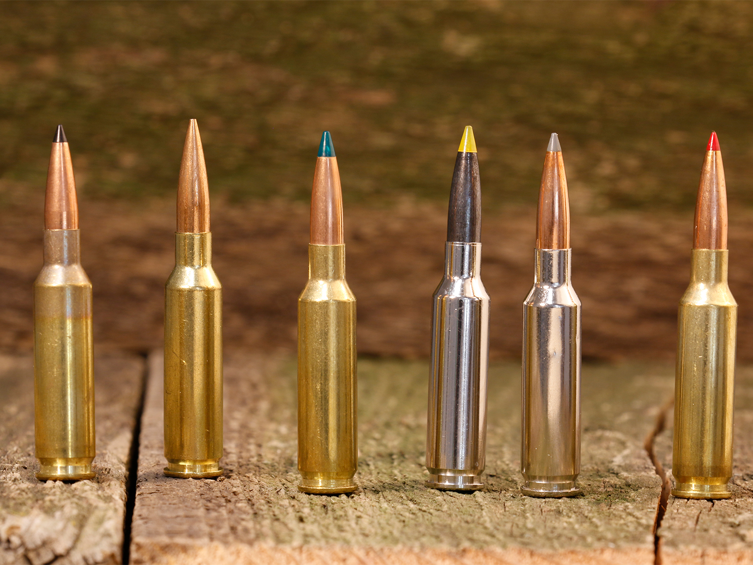 A lineup of 6.5 Creedmoor rifle cartridges on a wooden table.
