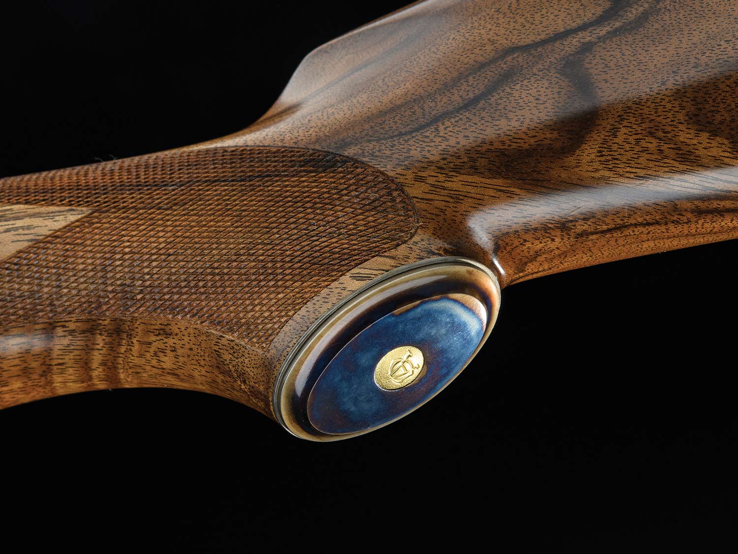 A case-colored grip cap on a rifle stock.