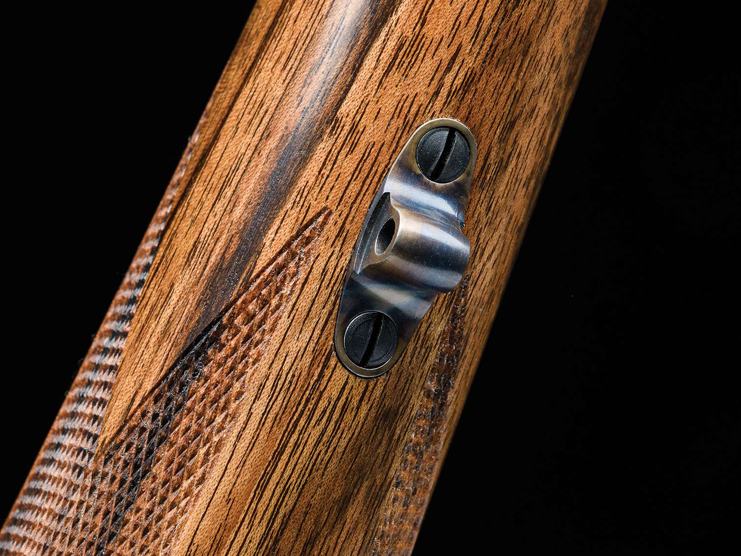 An inletted swivel stud on a rifle stock.