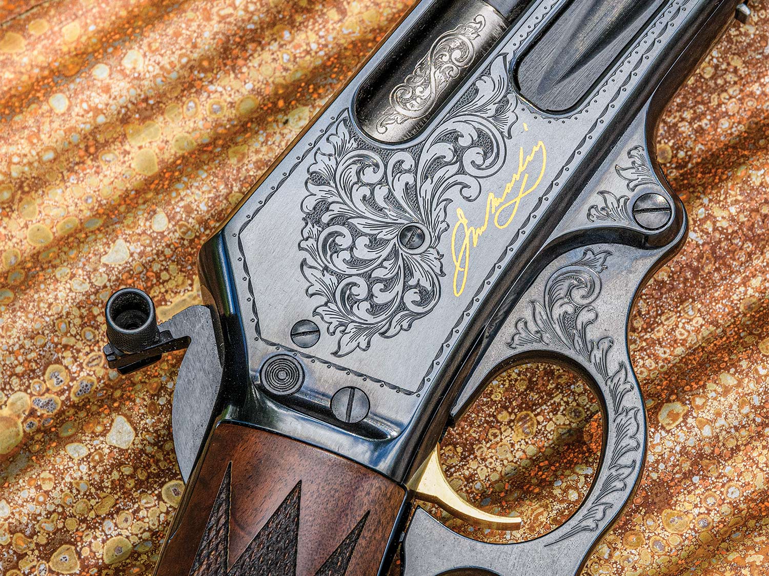 Close up detailings of engravings and design on a metal Marlin Anniversary Edition rifle.