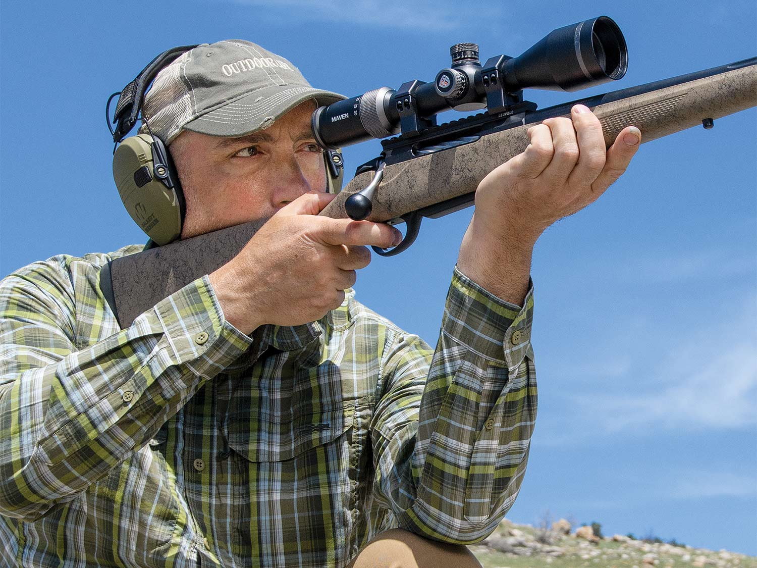 A man in a cap aims a Tikka T3x Lite Roughtech rifle during a gun test.